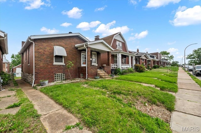 bungalow-style home featuring brick siding and a front yard