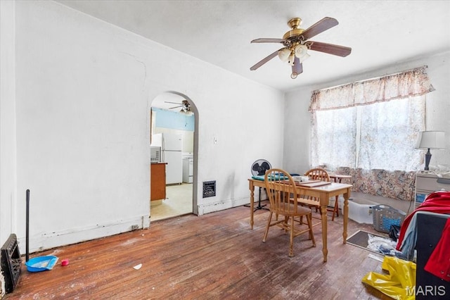 dining space featuring ceiling fan, hardwood / wood-style flooring, and arched walkways
