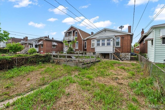 rear view of property featuring a garden and a fenced backyard