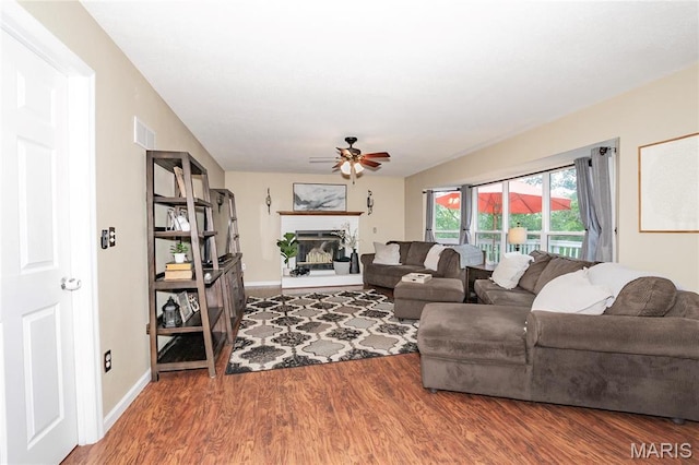 1408 Glacier Pass, Festus, MO 63028 - living room featuring a ceiling fan, a glass covered fireplace, wood finished floors, and baseboards