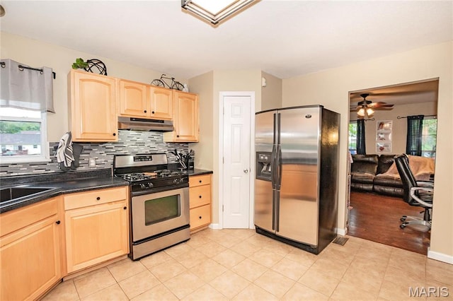 1408 Glacier Pass, Festus, MO 63028 - kitchen featuring appliances with stainless steel finishes, under cabinet range hood, light brown cabinets, dark countertops, and decorative backsplash