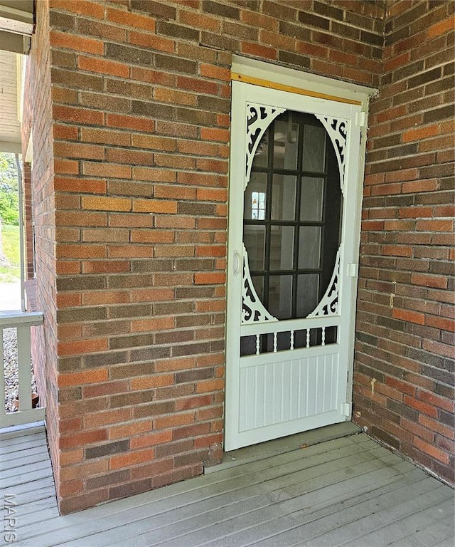 view of exterior entry with brick siding