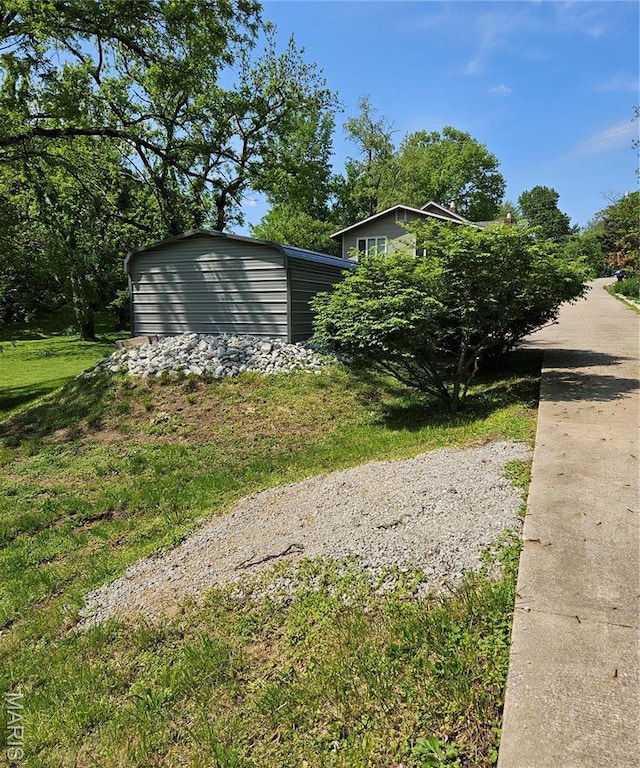 view of grassy yard featuring an outdoor structure and a storage unit