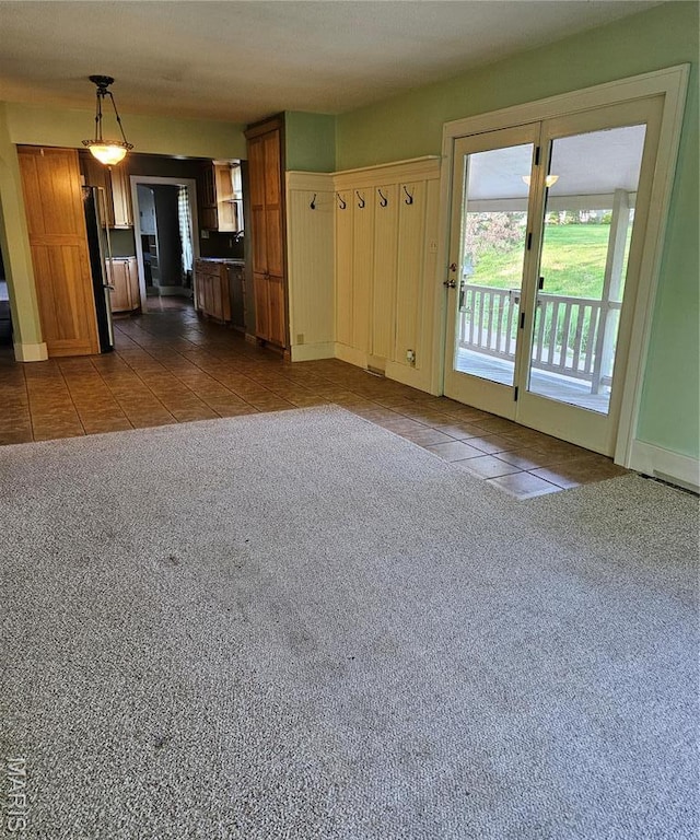 unfurnished living room featuring dark tile patterned flooring and dark colored carpet
