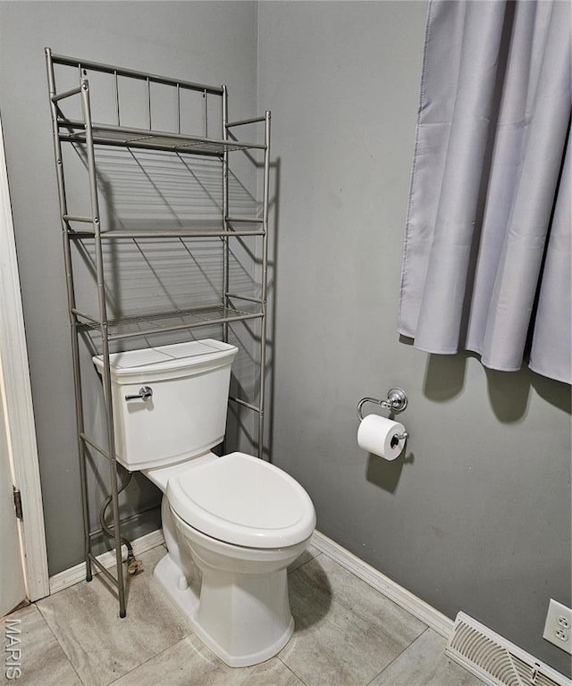 bathroom featuring baseboards and toilet
