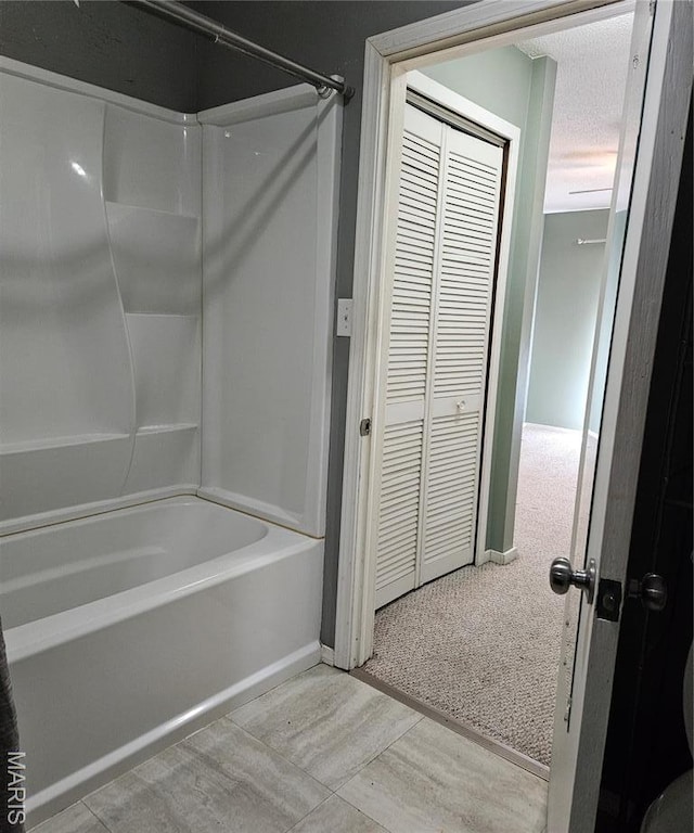 bathroom featuring tub / shower combination and baseboards