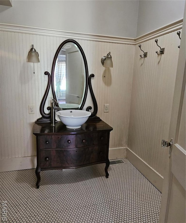 bathroom with vanity and wooden walls