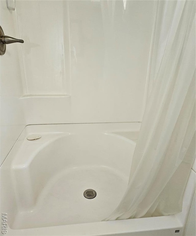 bathroom view of a shower with shower curtain