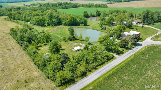 aerial view of property's location with a nearby body of water, rural landscape, and a tree filled landscape