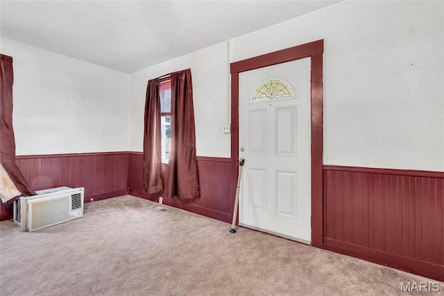 entryway with wainscoting, wood walls, carpet flooring, and healthy amount of natural light