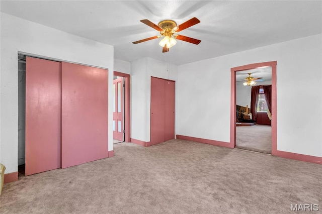 unfurnished bedroom featuring carpet floors, baseboards, and ceiling fan