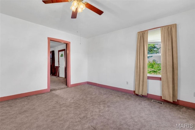 unfurnished room with carpet flooring, a ceiling fan, and baseboards