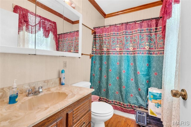 bathroom with crown molding, toilet, vanity, and wood finished floors