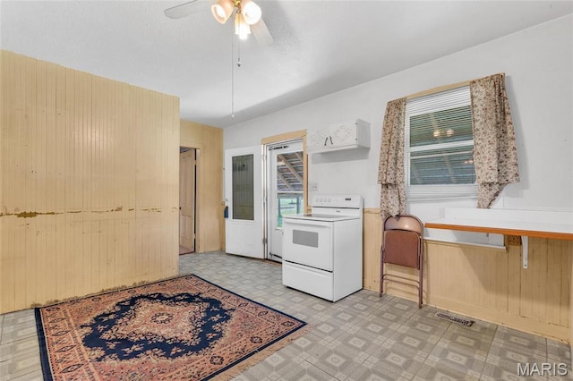 kitchen featuring white range with electric cooktop, tile patterned floors, ceiling fan, open shelves, and wooden walls