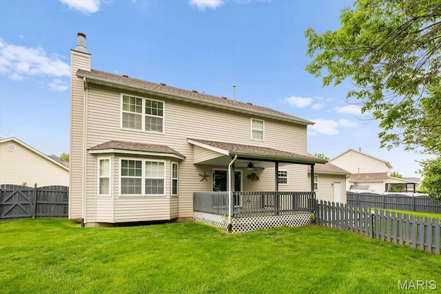 rear view of property with a chimney, ceiling fan, and a wooden deck