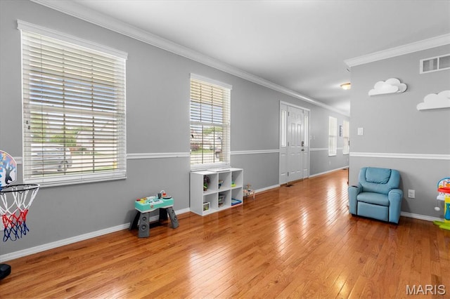 unfurnished room with light wood-style floors, crown molding, and baseboards