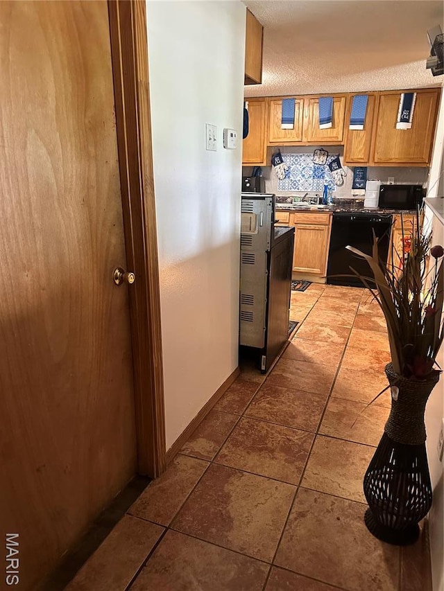 514 N 48th St E, St Louis, IL 62205 - kitchen featuring black microwave, light tile patterned floors, dishwasher, baseboards, and dark countertops