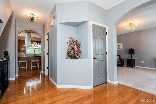 346 Palisades Ridge Ct, Eureka, MO 63025 - corridor with arched walkways, wood finished floors, a chandelier, and baseboards