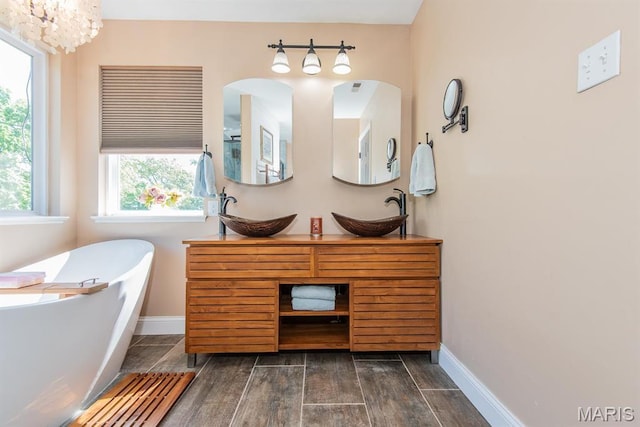 346 Palisades Ridge Ct, Eureka, MO 63025 - full bathroom featuring a freestanding tub, baseboards, wood finish floors, and double vanity