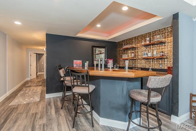 346 Palisades Ridge Ct, Eureka, MO 63025 - indoor wet bar featuring baseboards, a raised ceiling, recessed lighting, wood finished floors, and an accent wall