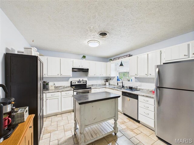 14469 Tailor Rd, Saint Robert, MO 65584 - kitchen with appliances with stainless steel finishes, under cabinet range hood, white cabinets, a sink, and a center island