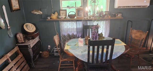 dining space featuring a wall mounted air conditioner, a chandelier, and wood finished floors