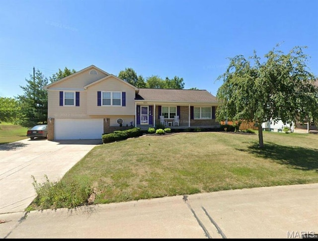 tri-level home with a porch, concrete driveway, an attached garage, and a front lawn