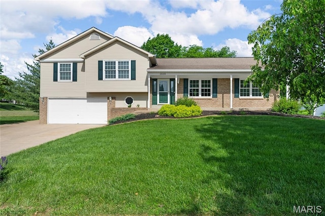 split level home featuring brick siding, an attached garage, driveway, and a front lawn