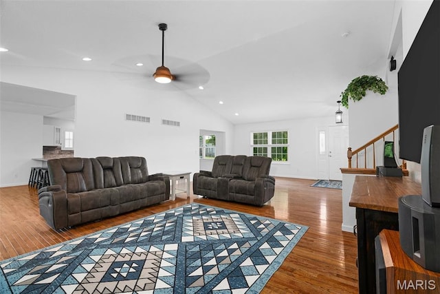living area with wood finished floors, a ceiling fan, recessed lighting, high vaulted ceiling, and stairway