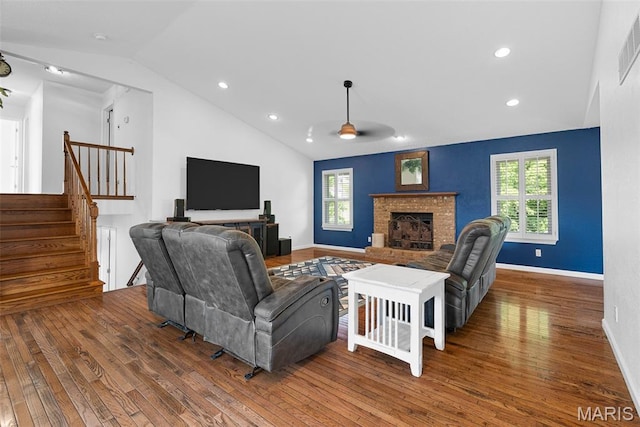 living area featuring wood-type flooring, lofted ceiling, ceiling fan, stairs, and healthy amount of natural light