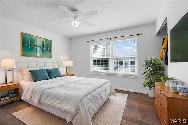 bedroom featuring dark wood-style floors, baseboards, and a ceiling fan