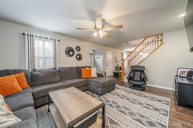 living room with dark wood-style flooring, stairs, ceiling fan, and baseboards