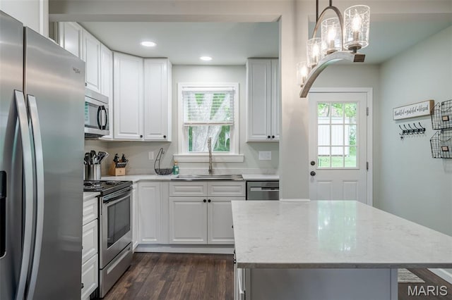 kitchen featuring appliances with stainless steel finishes, a sink, healthy amount of natural light, dark wood-type flooring, and recessed lighting