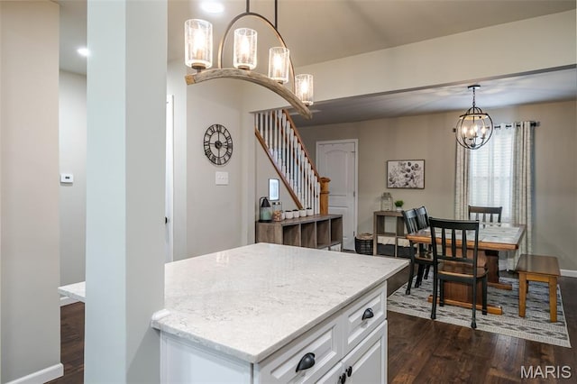 kitchen featuring a chandelier, dark wood finished floors, white cabinetry, hanging light fixtures, and baseboards