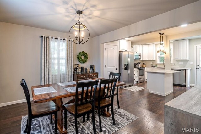 dining room featuring a chandelier, dark wood finished floors, and baseboards