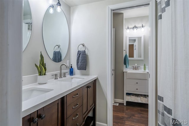 full bath with wood finished floors and double vanity