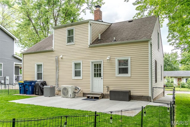 rear view of house with a chimney, a patio, ac unit, a shingled roof, and central air condition unit