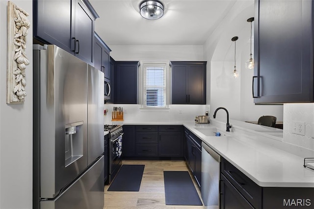 1606 Mississippi Ave, Saint Louis, MO 63104 - kitchen with appliances with stainless steel finishes, a sink, light wood-style floors, light countertops, and decorative light fixtures