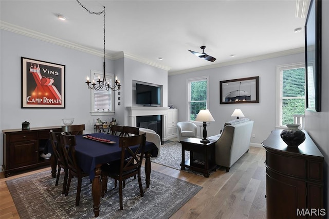 1606 Mississippi Ave, Saint Louis, MO 63104 - dining area featuring light wood-style floors, a glass covered fireplace, crown molding, baseboards, and a chandelier