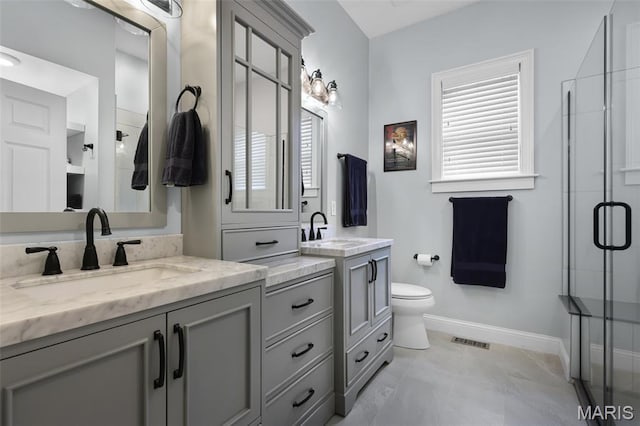 1606 Mississippi Ave, Saint Louis, MO 63104 - full bathroom with a shower stall, two vanities, baseboards, and healthy amount of natural light