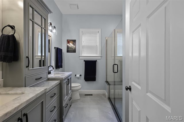 1606 Mississippi Ave, Saint Louis, MO 63104 - full bathroom featuring a stall shower, two vanities, baseboards, toilet, and marble finish floors