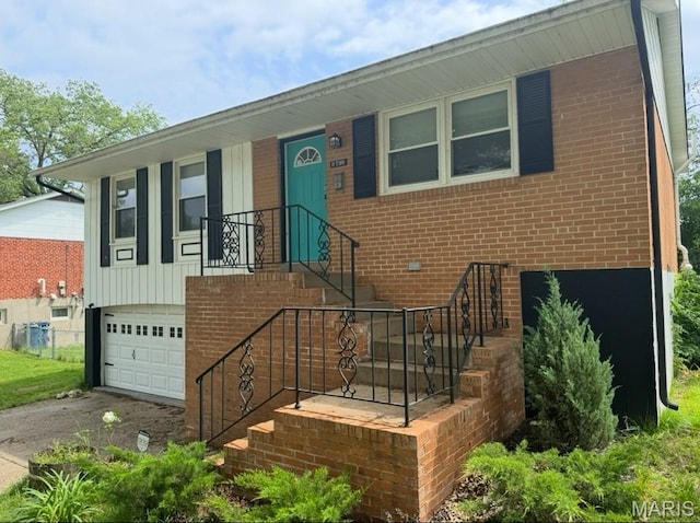 view of front facade with driveway, a garage, and brick siding