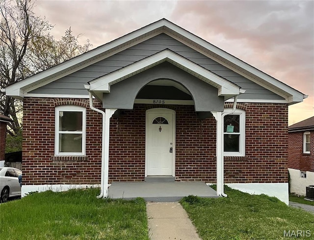 8705 Kendale Dr, Saint Louis, MO 63121 - ranch-style house with brick siding, a front lawn, and central air condition unit