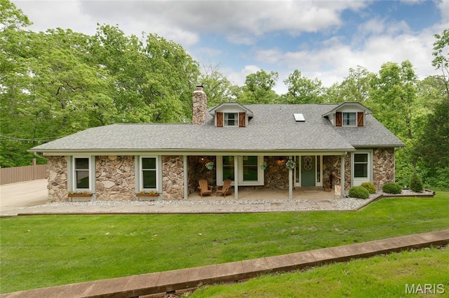 back of house with stone siding, a chimney, roof with shingles, and a porch