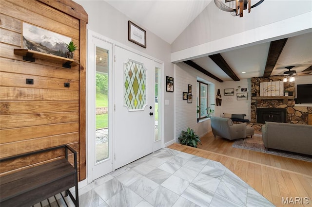 foyer featuring a fireplace, ceiling fan, plenty of natural light, and baseboards