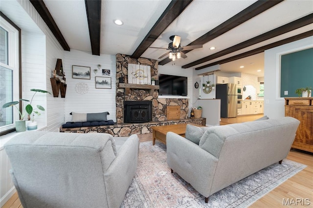 living room featuring light wood-type flooring, a ceiling fan, beam ceiling, and recessed lighting