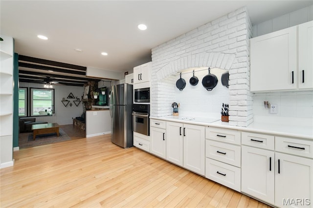 kitchen with appliances with stainless steel finishes, light wood-style floors, light countertops, backsplash, and recessed lighting
