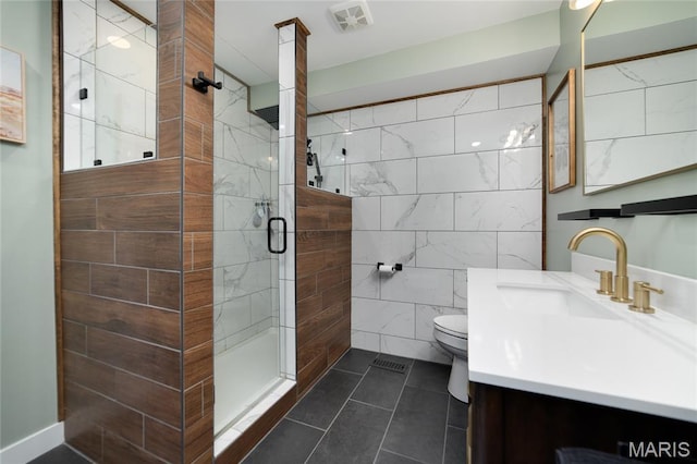 full bath with tile walls, a shower stall, tile patterned floors, vanity, and toilet