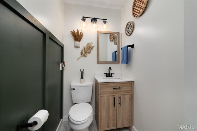 half bath featuring baseboards, toilet, and vanity