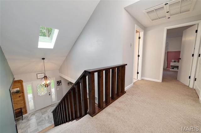 staircase featuring a skylight, high vaulted ceiling, carpet floors, and baseboards